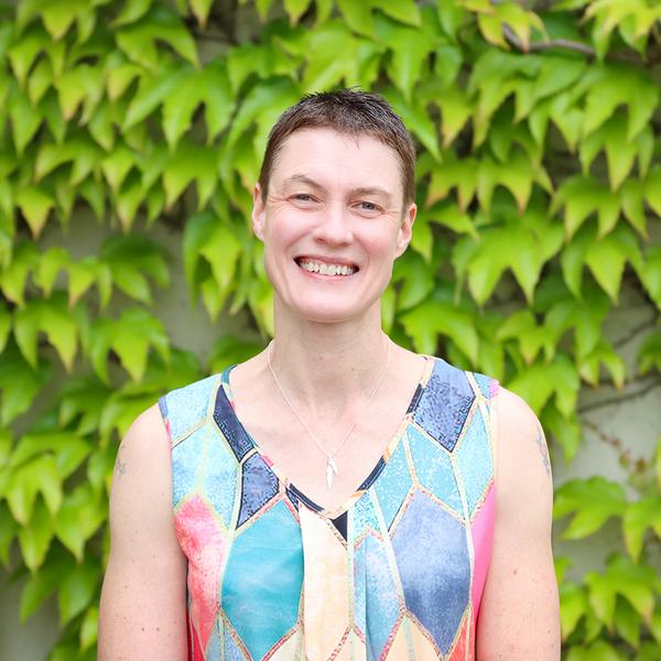 Emily Huner stands in front of foliage at VIU's Nanaimo campus