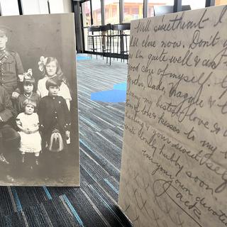 A picture of a solider and his family to the left, a copy of a letter in the foreground