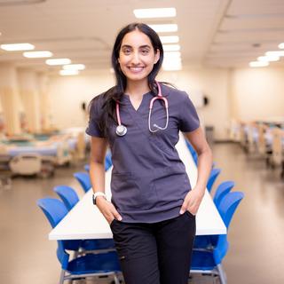 Ashley stands in VIU's nursing simulation lab, wearing scrubs and a stethoscope