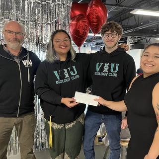 Group of four people holding a cheque