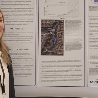 Ally Badger stands in front of a research poster.