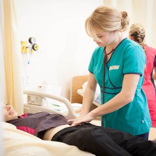 A nursing student practices on another nursing student