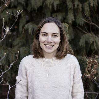 Kimberly Coleman, a woman is standing in front of trees