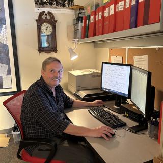 Dr. Stephen Davies sits in front of his computer, which displays a digitized letter