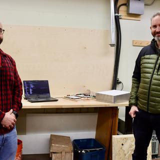 Engineering Technician Devin Ayotte and Resource Management and Protection Technician Michael Lester stand in front of marmot weigh scale