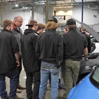 students crowded around a car