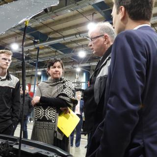 President Saucier, Minister Ralston and MLA Walker talk with a student