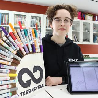 Emma StLaurent holds up her display of recycled pens.