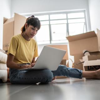 A student looks at a laptop screen surrounded by boxes