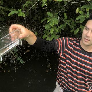 Joe Clark holds a container with a cutthroat trout fry.