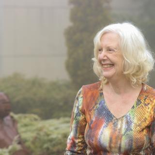 Pam Vickars stands in a garden area.