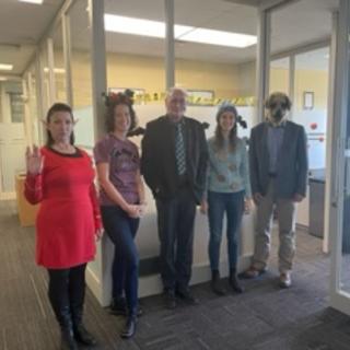 Four people in Halloween costumes in an office. 