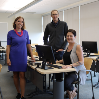 From left to right: Tracy Vandermolen, Darrell Harvey and Anwen Burk in a computer lab and smiling at the camera