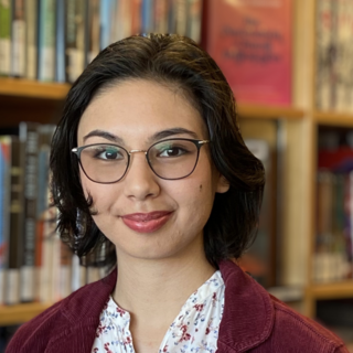 Chiara Sedola standing in front of a bookshelf and smiling at the camera