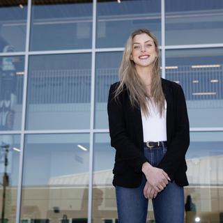 Teagan stands outside the glass windows on the Centre for Health and Science at VIU's Nanaimo campus