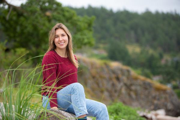 Portrait of Marissa sitting on grass smiling at camera