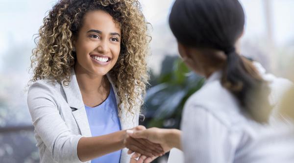 a woman shakes hands with another woman