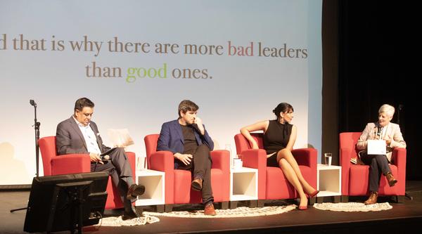 Four people sit on a stage together