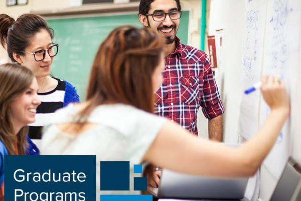 Students collaborating at a white board with Graduate Programs Expo written on the side