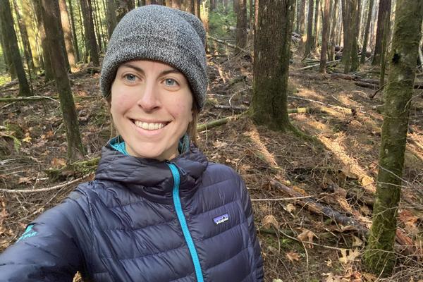 Nadia Linning standing in the woods and smiling at the camera