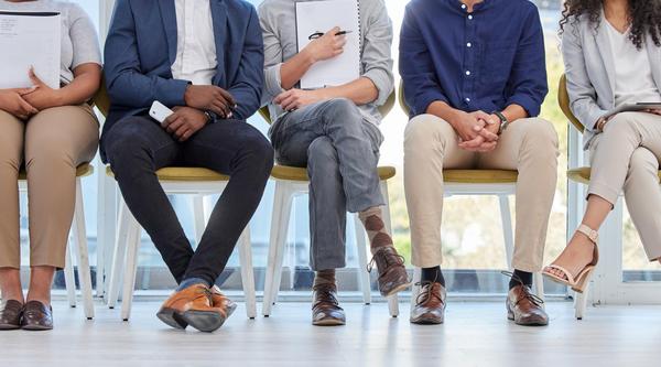 closeup of students' legs dressed in business attire sitting on chairs