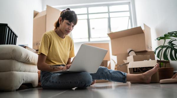 A student looks at a laptop screen surrounded by boxes