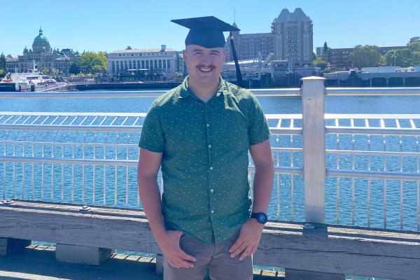 VIU Criminology grad Liam Kenney posing in his grad hat