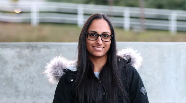 Portrait of Nina Gill sitting and smiling at the camera