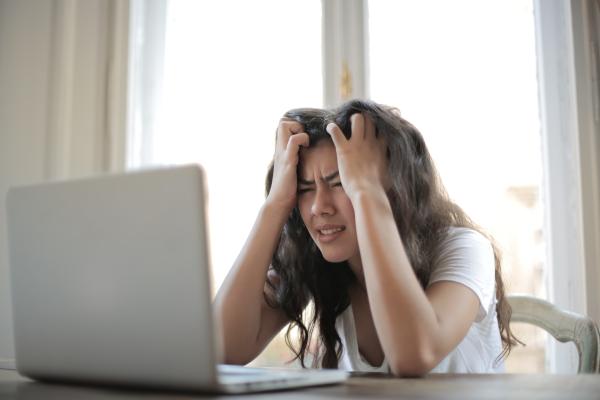 Girl staring at a computer screen with head in hands