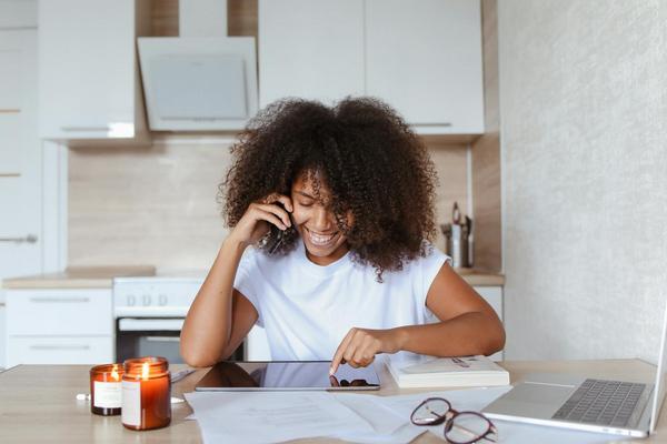 A woman looks at a tablet while sitting at a table