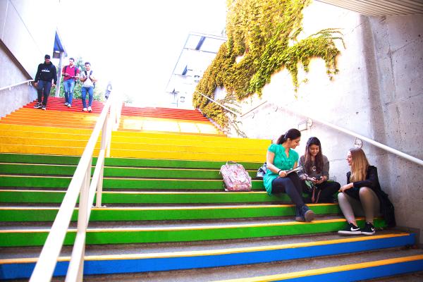 People sitting on rainbow stairs at VIU's Nanaimo campus