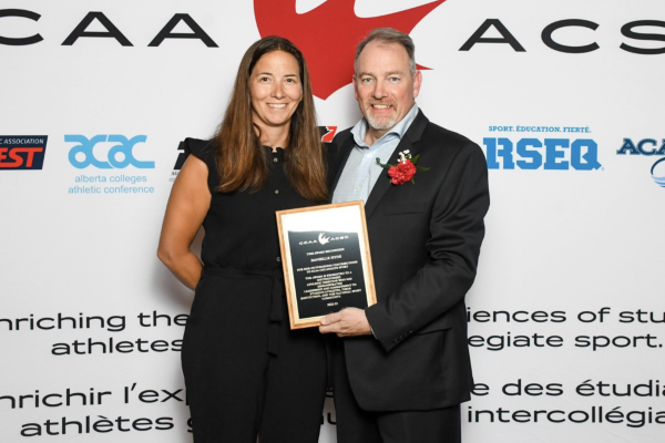 Danielle Hyde on the left receiving her award from a CCAA representative