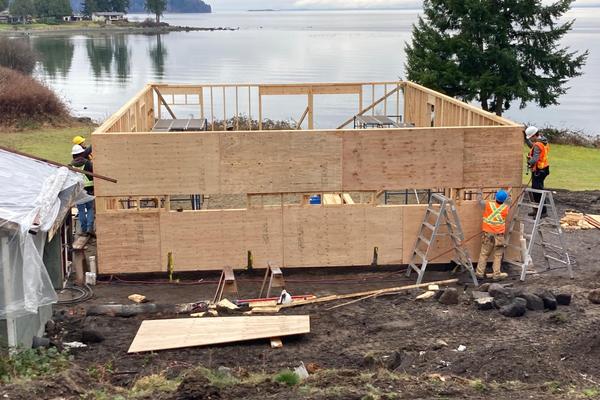 Students frame up a home with an ocean view in the background