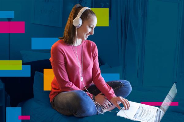 Girl with headphones on looking at a computer