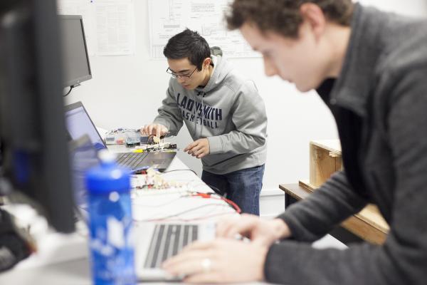 Two VIU Engineering students work on computer equipment in a lab.