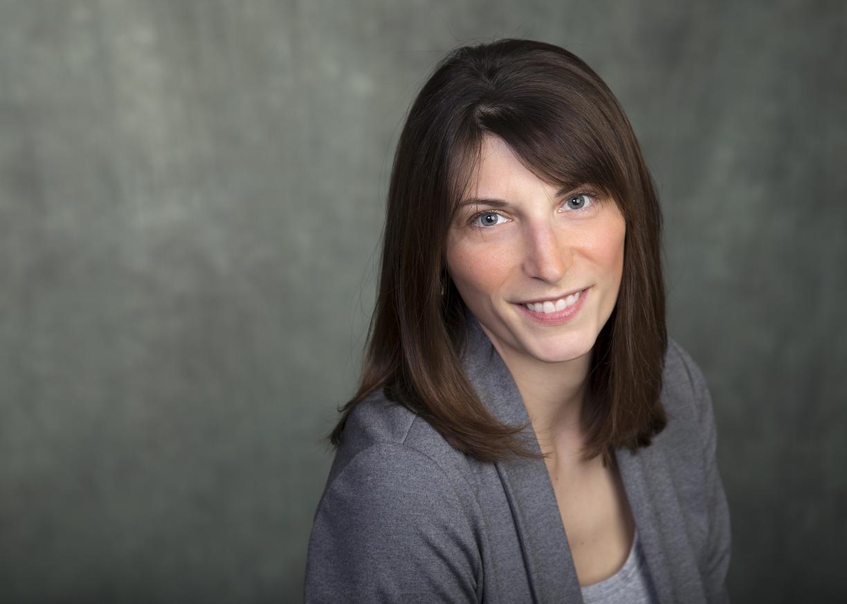 Headshot of Dr. Lindsay McCunn, wearing a grey blazer and smiling.