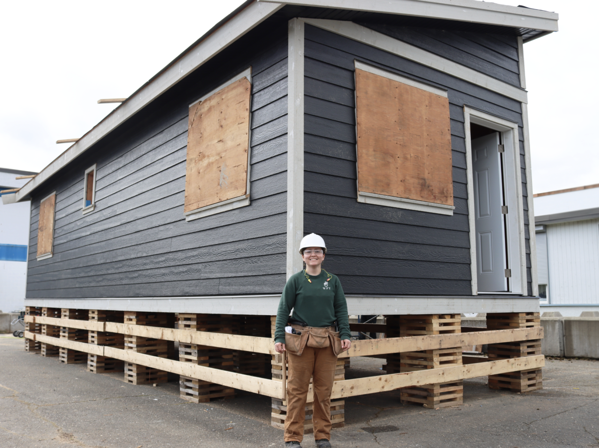 Carpentry student Emily Behm standing in front of the tiny home she and her classmates are building at the Cowichan Trades Centre