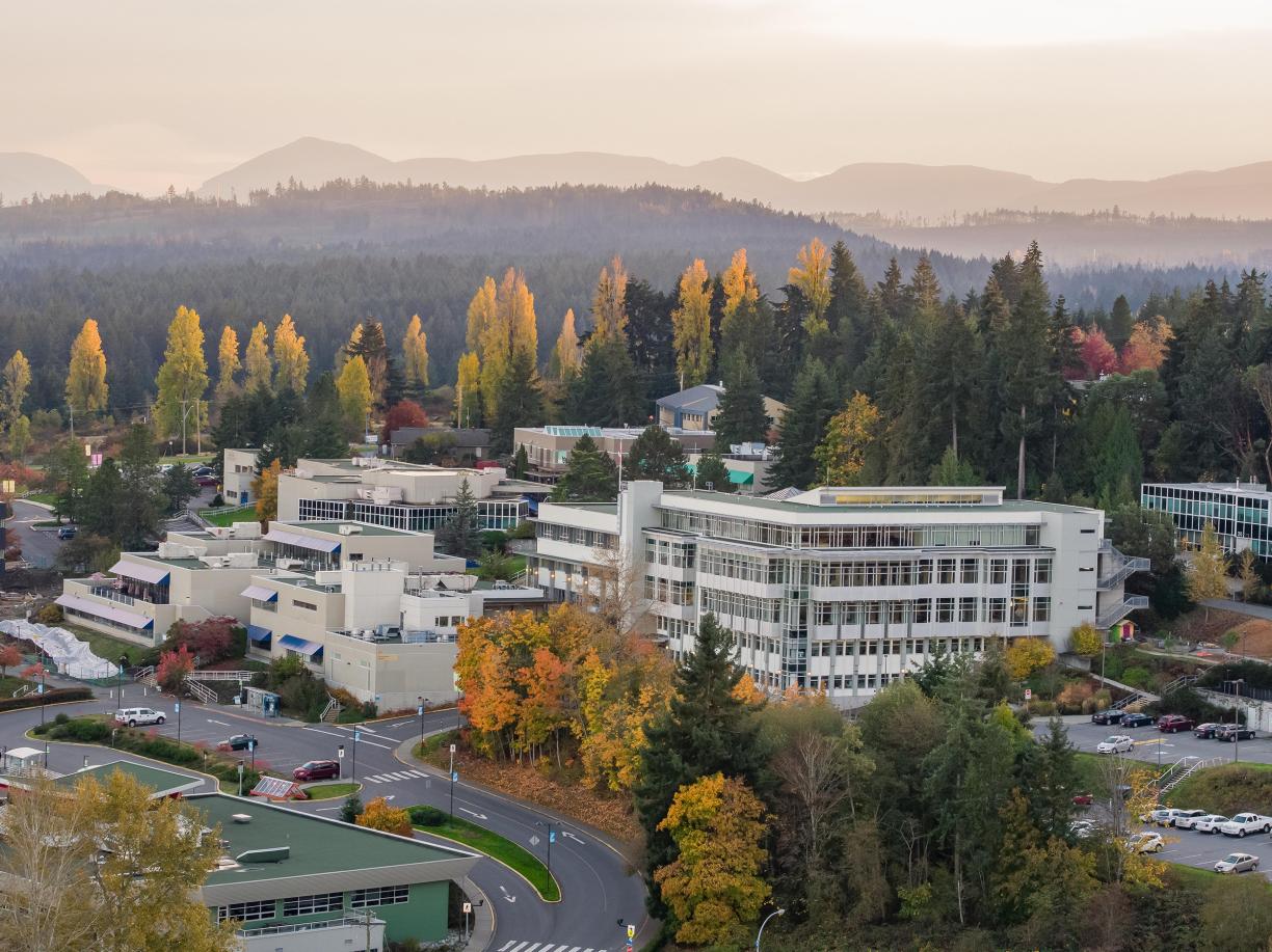 An aerial view of VIU's Nanaimo campus during the fall trees dappled with yellow and orange leaves.