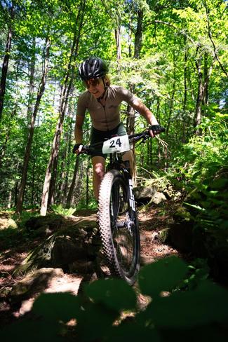 Kimberly Coleman is riding a mountain bike on a trail in the woods